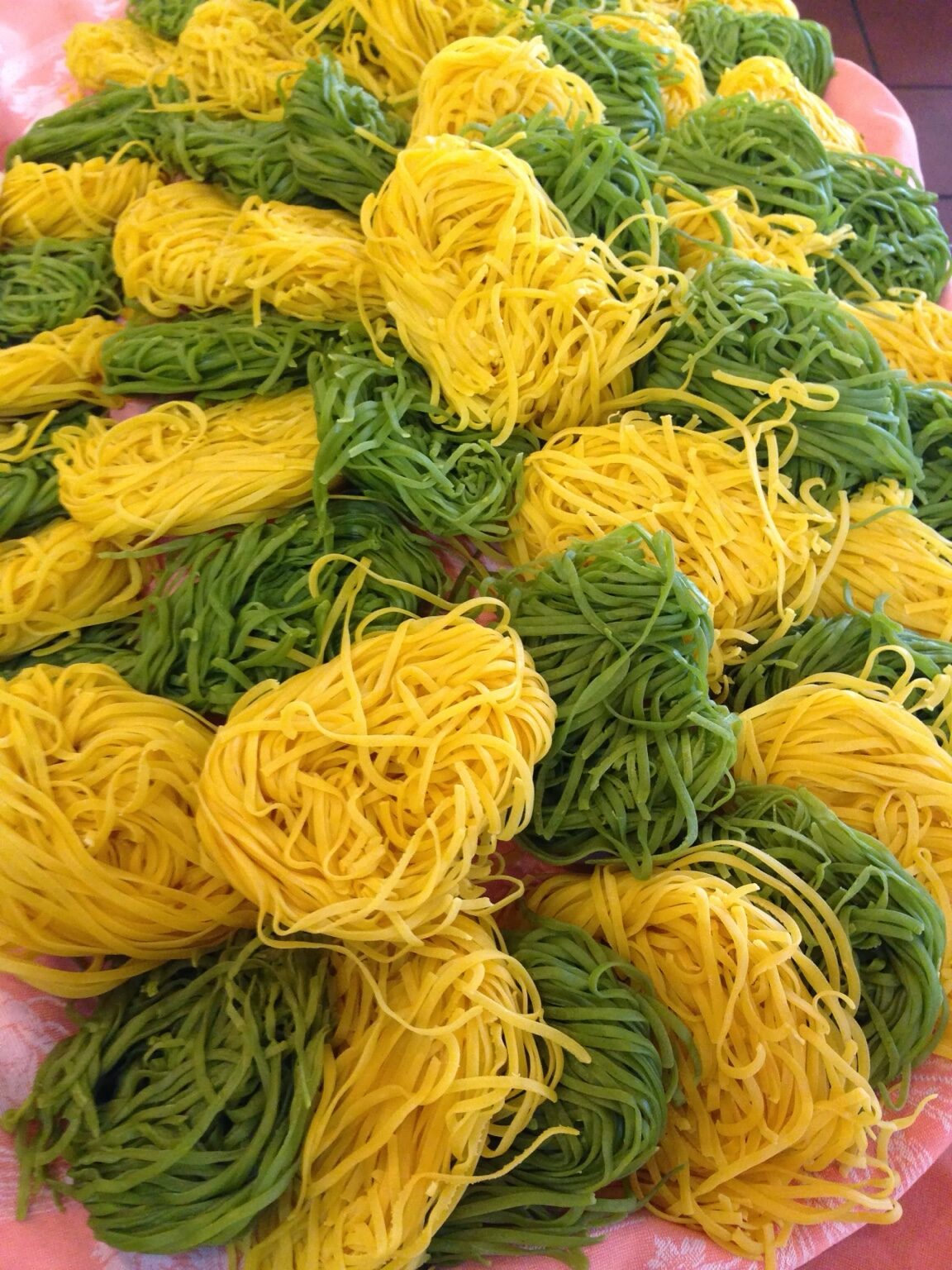 Nidi di pasta fresca gialla e verde preparati alla Trattoria Ai Due Orsi